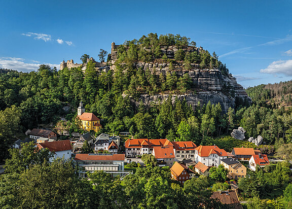 Im Tal eingebetet liegt Oybin. Im Hintergrund sehen wir den Berg Oybin mit der historischen Bergkirche und der Klosterruine.